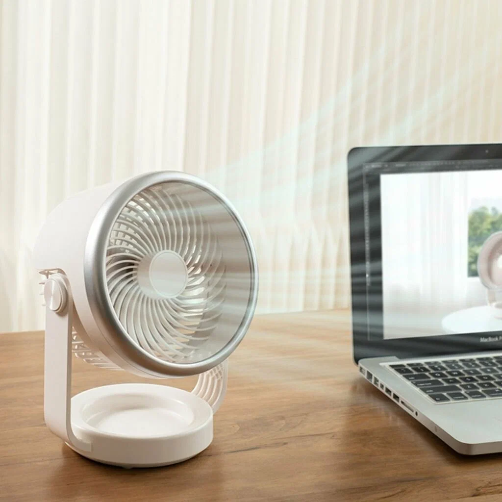 CoolSwing desktop fan with swinging airflow beside a laptop